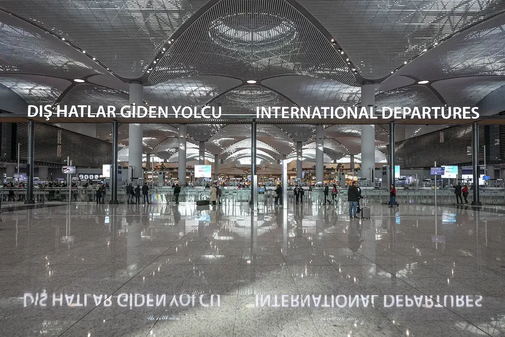 The vast main terminal of Istanbul Airport with travelers and tall windows