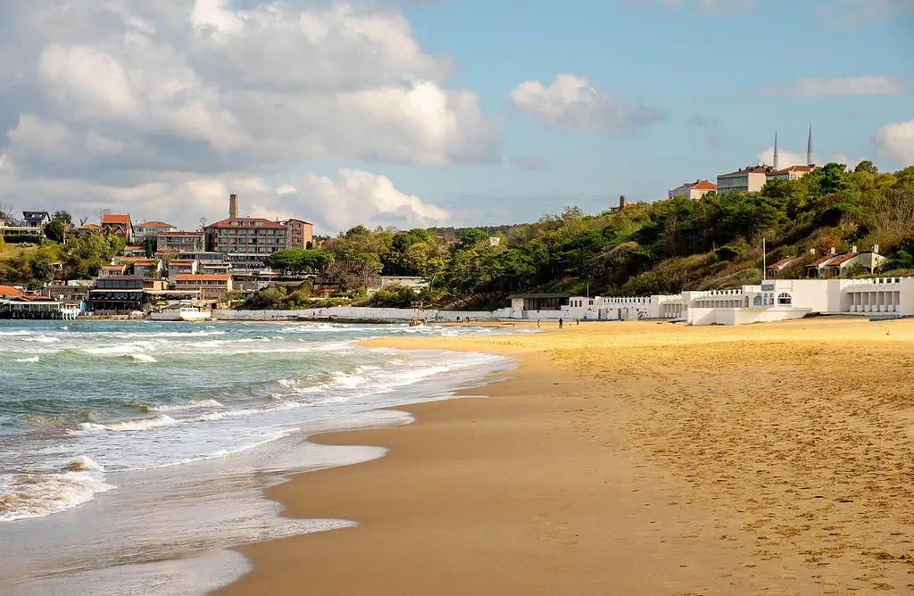 A wide sandy Black Sea beach at Kilyos near Istanbul with open water and waves under a summer sky