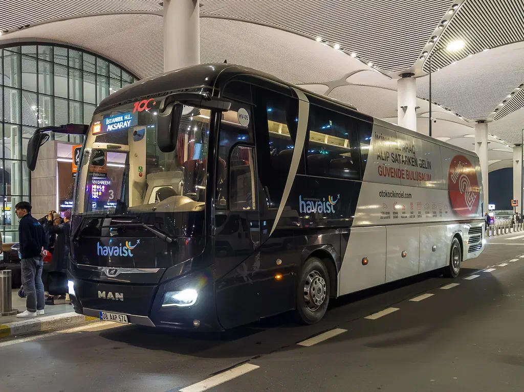 A white Havaist airport shuttle coach at a stop outside Istanbul Airport