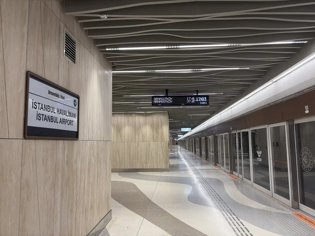 A blue and white M11 metro train at an Istanbul Airport line platform